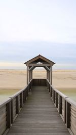 Boardwalk on beach against sky