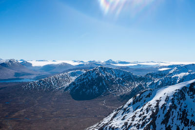 Scenic view of snowcapped mountains against clear blue sky