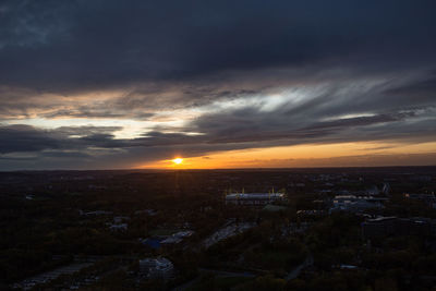 Aerial view of city buildings against sky during sunset