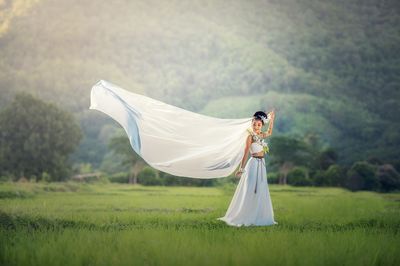 Woman with umbrella standing on field