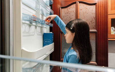 Side view of woman standing in corridor