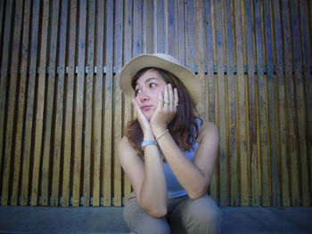 Portrait of beautiful young woman sitting in hat