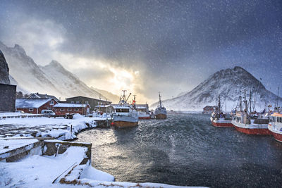 Scenic view of sea by snowcapped mountains against sky