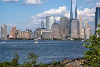 Sea by buildings against sky in city