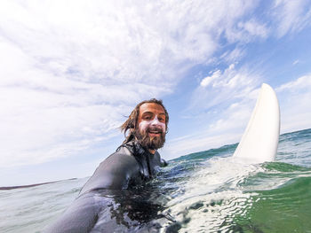 Portrait of smiling man in sea against sky