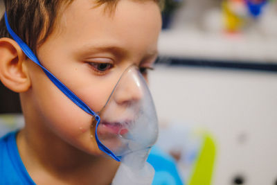 Close-up of boy wearing oxygen mask in hospital