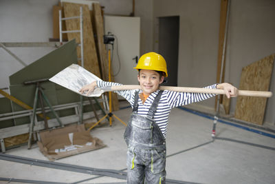 Portrait of boy standing on slide at construction site