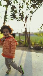 Full length of girl standing on road against sky