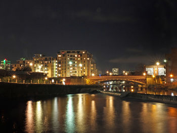 Cityscape view of leeds from the river aire at night with illuminated buildings