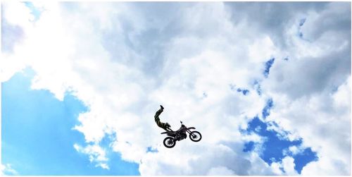 Low angle view of parachute against cloudy sky