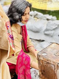 Side view of young woman sitting in temple