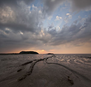 Scenic view of beach against sky during sunset