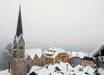 Snow covered roofs of idyllic town on moody winter day. hallstatt, austria.