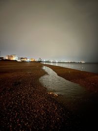 Scenic view of beach against clear sky at night