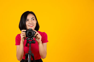 Portrait of smiling woman holding camera