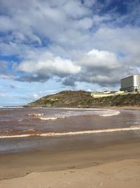 View of beach against cloudy sky