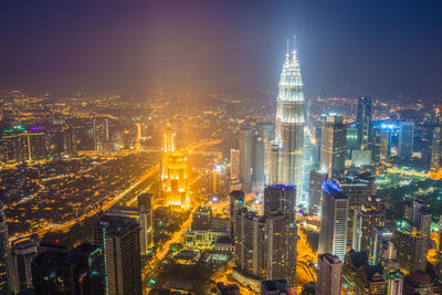 Aerial view of illuminated buildings in city at night