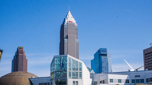 Low angle view of modern buildings against blue sky
