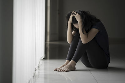 Side view of a woman sitting at home