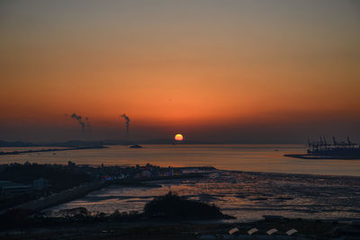 Scenic view of sea against orange sky