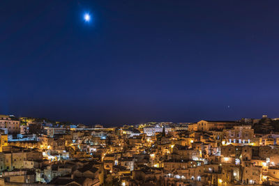 High angle shot of illuminated townscape against blue sky