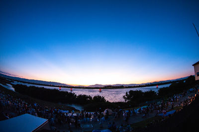 Crowd at music concert against sky at sunset