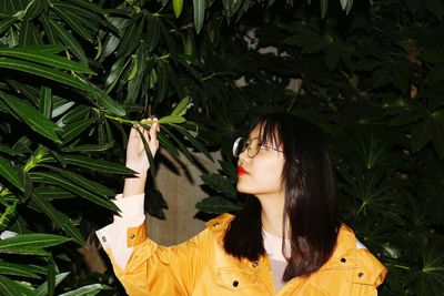 Portrait of woman standing by plants