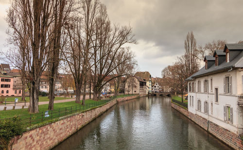 Canal amidst buildings against sky