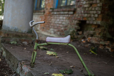 Abandoned bicycle against wall