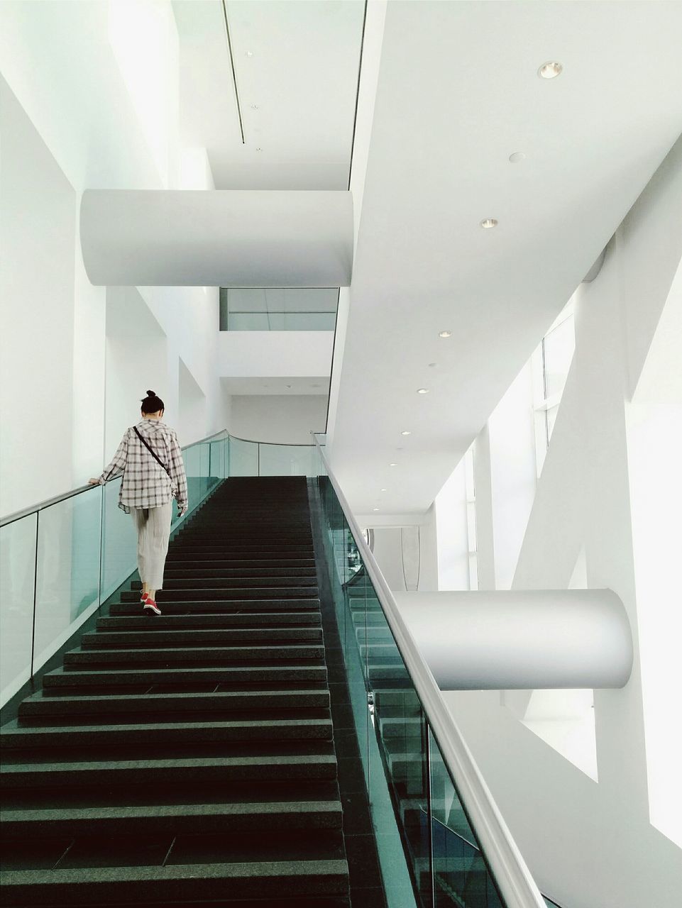 steps and staircases, steps, staircase, railing, built structure, architecture, stairs, low angle view, indoors, the way forward, building, modern, full length, building exterior, day, wall - building feature, escalator, one person, moving up