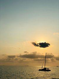 Sailboat in sea against sky during sunset