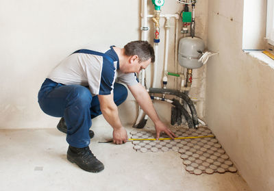 Side view of plumber working at home