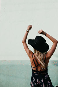 Rear view of woman standing against wall