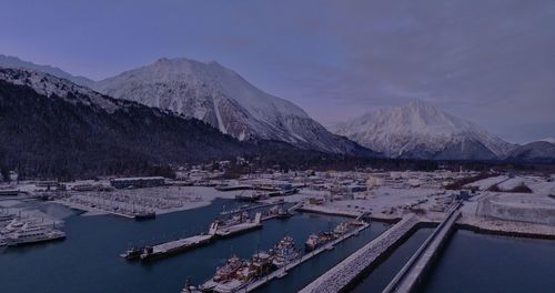 Scenic view of lake by snowcapped mountains against sky