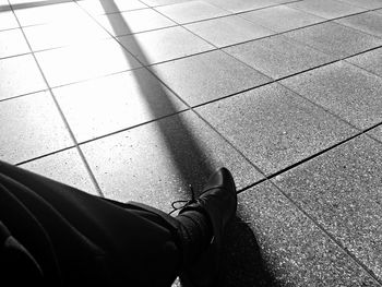 Low section of woman standing on tiled floor