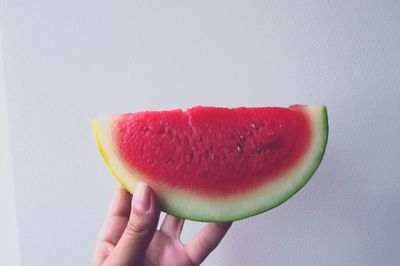 Close-up of cropped hand holding watermelon slice