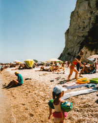 People on beach against clear sky