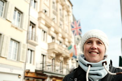 Portrait of young woman standing in city