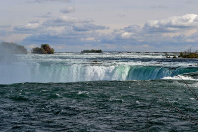 Scenic view of waterfall against sky