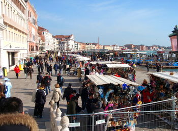 People on street in city against sky