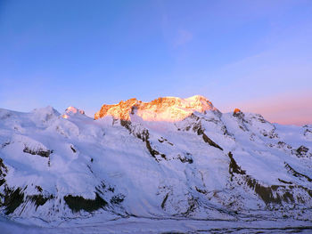 Scenic view of snowcapped mountains against clear blue sky