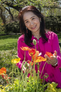 Portrait of a smiling young woman holding flowering plants