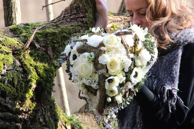 Midsection of woman holding flower bouquet