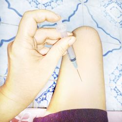 Cropped image of person injecting on thigh