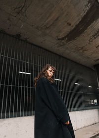 Portrait of woman standing against wall