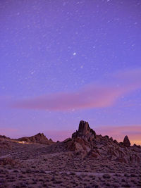 Campers on a ridge, star trails in the sky, alabama hills.