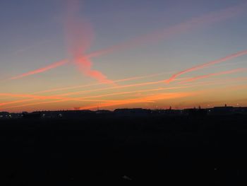 Silhouette landscape against dramatic sky during sunset