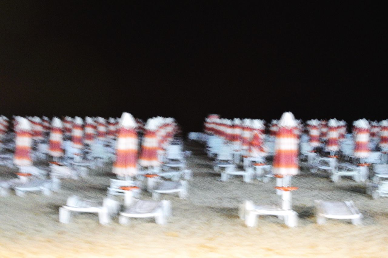 BLURRED MOTION OF PEOPLE AT ILLUMINATED STREET LIGHTS