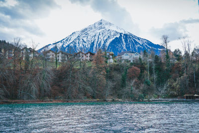 Scenic view of lake by mountains against sky