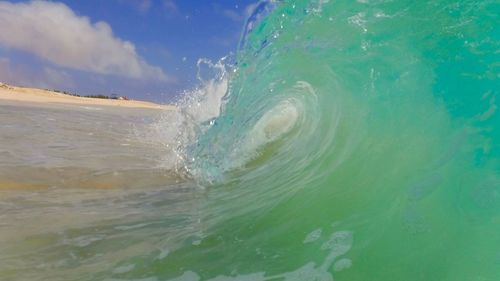 Water splashing in sea against sky